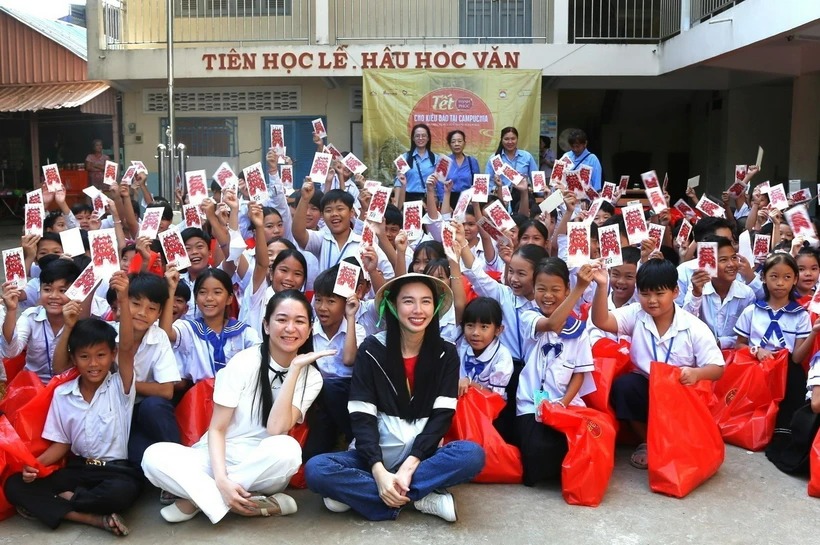 Hoa hậu Hòa bình Quốc tế 2021 Nguyễn Thúc Thùy Tiên chụp ảnh cùng các em học sinh người gốc Việt tại Trường Tiểu học Hữu nghị Khmer-Việt Nam Tân Tiến. (Ảnh: Hoàng Minh/TTXVN)